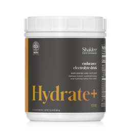 A white plastic container of Shaklee Performance Hydrate+ endurance electrolyte drink in orange flavor, featuring product details on a gray and yellow label—an essential addition to your Shaklee Sports nutrition routine.